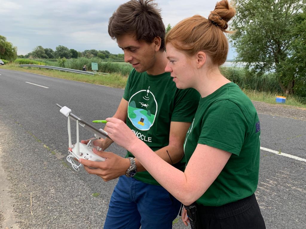 2 people checking the data that is being captured with a drone